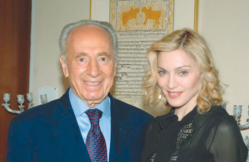 THEN-PRESIDENT Shimon Peres poses with pop singer Madonna during their meeting at the President’s Residence in Jerusalem in September 2007.  (credit: MOSHE MILNER/GPO/REUTERS)