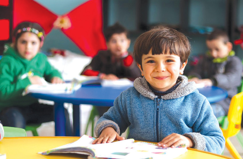 A CHILD sits in a classroom in Syria earlier this year. (photo credit: KHUDR AL-ISSA/UNICEF)