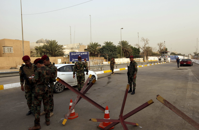 Iraqi security forces gather at a checkpoint as cars cross into the Green Zone in Baghdad, Iraq. (photo credit: REUTERS)