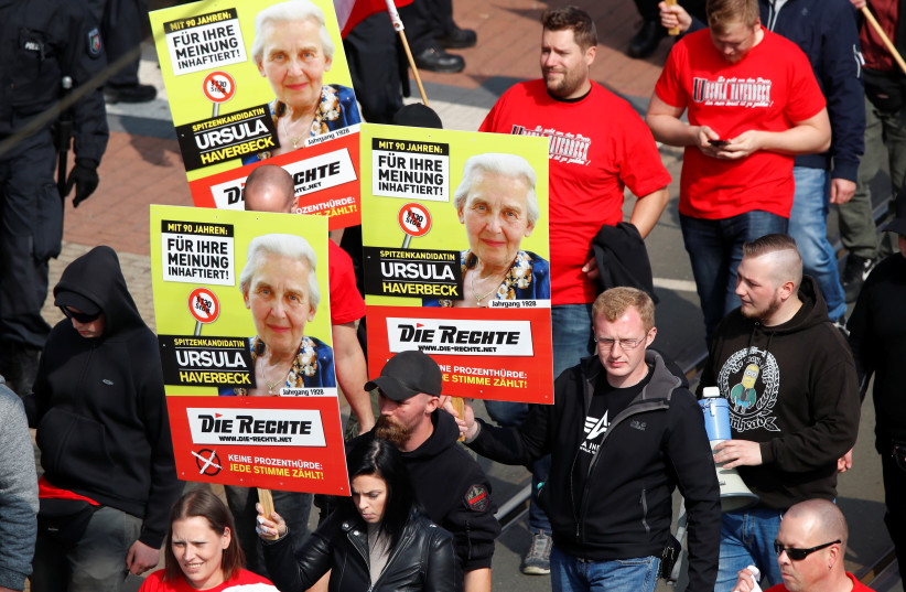 Far-right supporters of the party "Die Rechte (The Rights) carry placards of 90-year-old Ursula Haverbeck, who is imprisoned for her denial of the Holocaust during their May Day rally through the streets of Duisburg, Germany, May 1, 2019 (photo credit: WOLFGANG RATTAY / REUTERS)