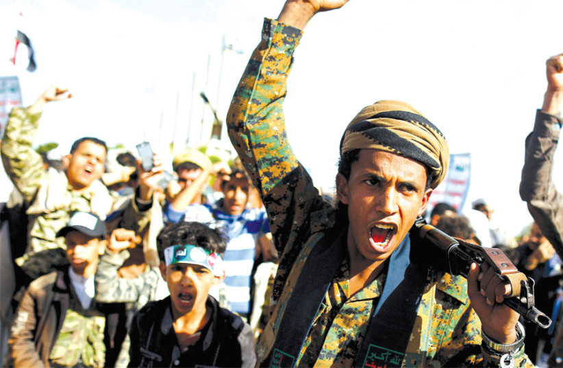 HOUTHI MOVEMENT supporters shout slogans as they attend a rally to mark the fourth anniversary of the Saudi-led military intervention in Yemen’s war, in Sana’a, Yemen, on March 26. (photo credit: REUTERS)