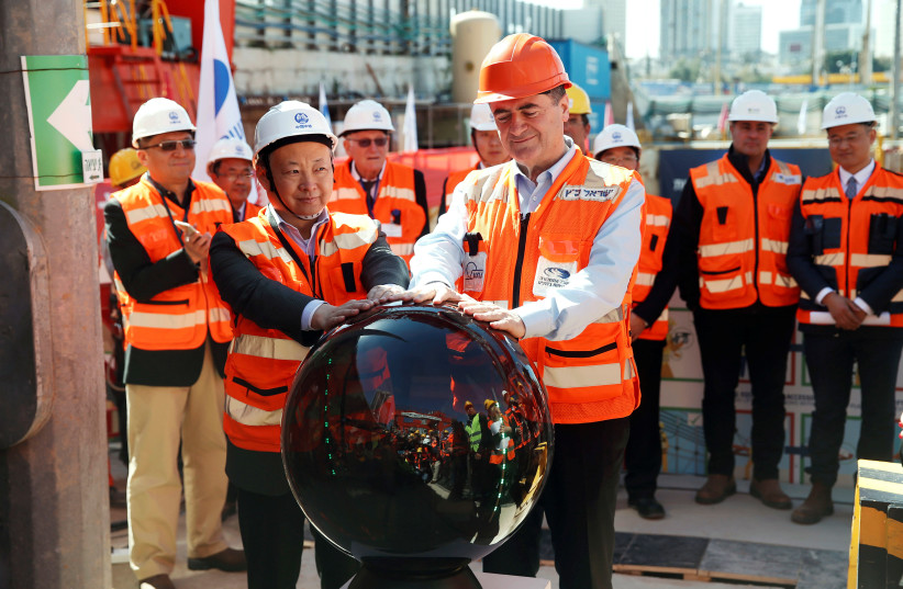 Yisrael Katz (front), Israel's Minister of Transport, and employees of China Railway Engineering Corporation, take part in an event marking the beginning of underground construction work of the light rail, using a Tunnel Boring Machine (TBM), in Tel Aviv in 2017 (photo credit: BAZ RATNER/REUTERS)