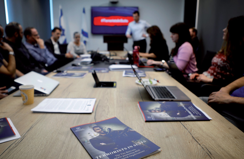 Israel’s Ministry of Strategic Affairs briefs reporters in Bnei Brak on February 3 on its new report revealing ties between terrorist groups and NGOs that support the BDS movement (photo credit: NIR ELIAS / REUTERS)