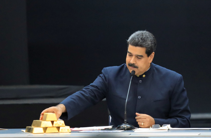 Venezuela's President Maduro touches a gold bar as he speaks during a meeting with the ministers responsible for the economic sector in Caracas (credit: MARCO BELLO/REUTERS)