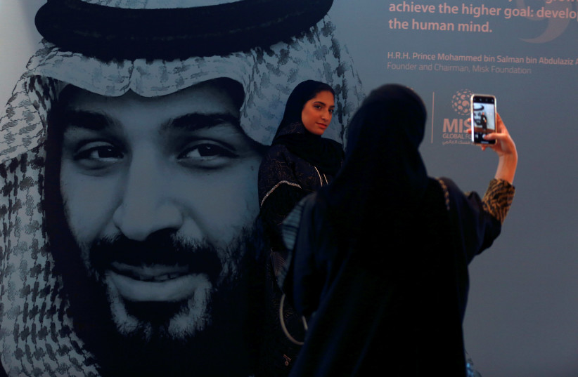  Participants take photos next to a picture of Saudi Crown Prince Mohammed bin Salman during the Misk Global Forum in Riyadh, Saudi Arabia (photo credit: FAISAL AL NASSER/ REUTERS)