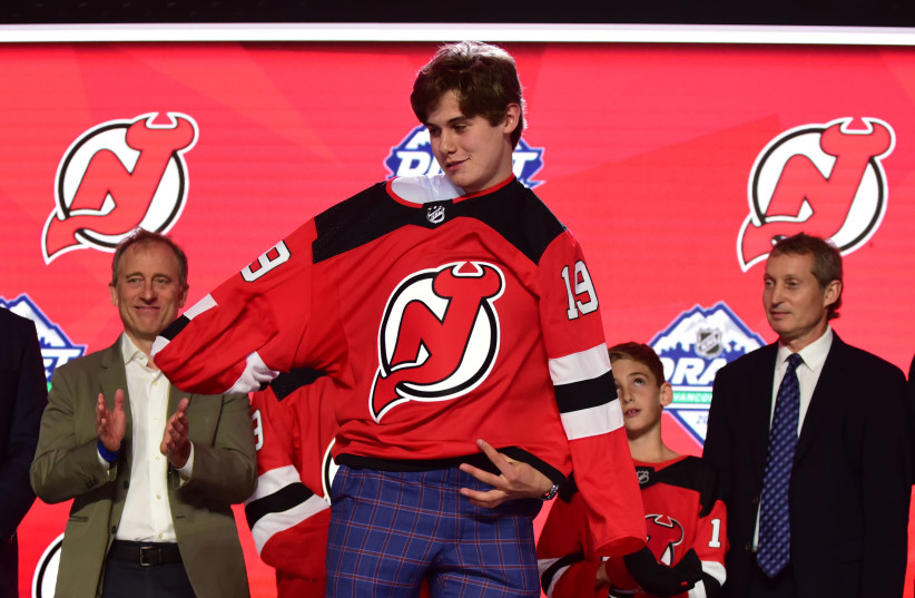 Jun 21, 2019; Vancouver, BC, Canada; Jack Hughes puts on a team jersey after being selected as the number one overall pick to the New Jersey Devils in the first round of the 2019 NHL Draft at Rogers Arena. (photo credit: ANNE-MARIE SORVIN-USA TODAY SPORTS)
