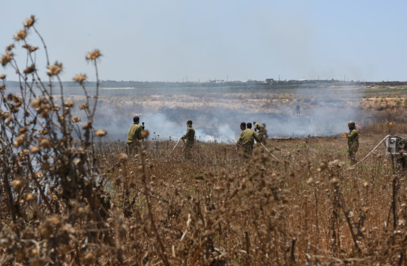 IDF firefighters extinguishing a fire in Gaza Envelope in south Israel, one of 25 fires in the region today, caused by incendiary balloons, sent by terrorists from Gaza. Gaza Envelope, Jun 27, 2019 (photo credit: AVIV HERTZ/ TPS)