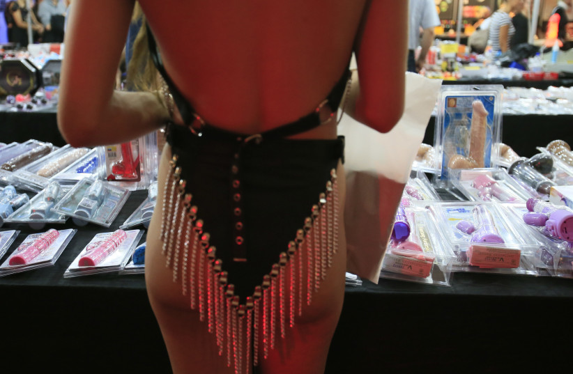 A woman looks at sex toys at a display booth during the last day of the 16th "Venus" erotic fair in Berlin October 20, 2012.  (photo credit: TOBIAS SCHWARZ / REUTERS)
