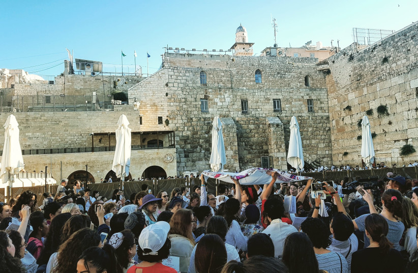 Women of the Wall read the Torah while praying in the women's section of the Kotel plaza (photo credit: ILANIT CHERNICK)