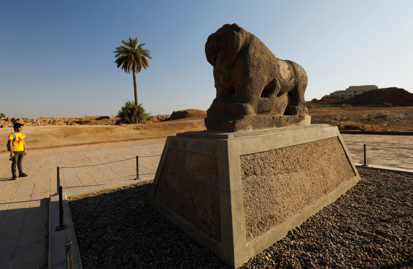 A man looks at the statue of the Lion of Babylon in the ancient city of Babylon near Hilla, Iraq July 5, 2019.  (credit: THAIER AL-SUDANI/REUTERS)