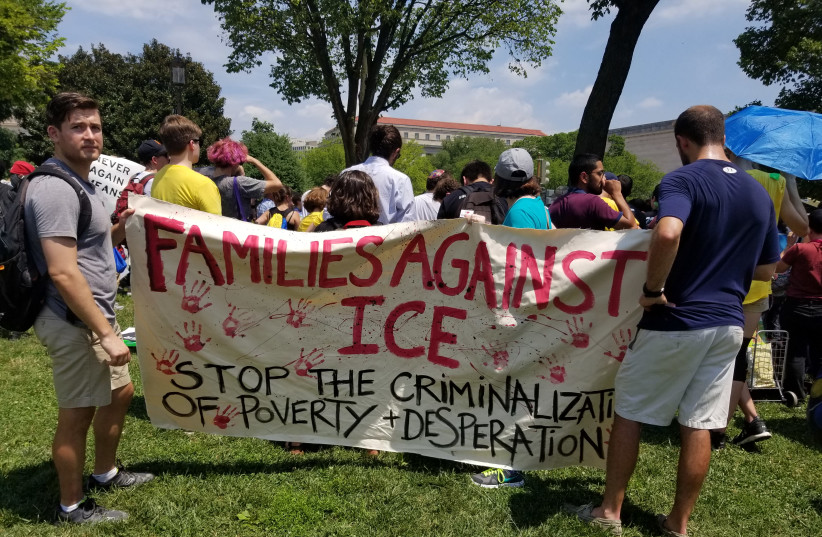 People hold signs 'Families against ICE' at immigration protest (photo credit: OMRI NAHMIAS)