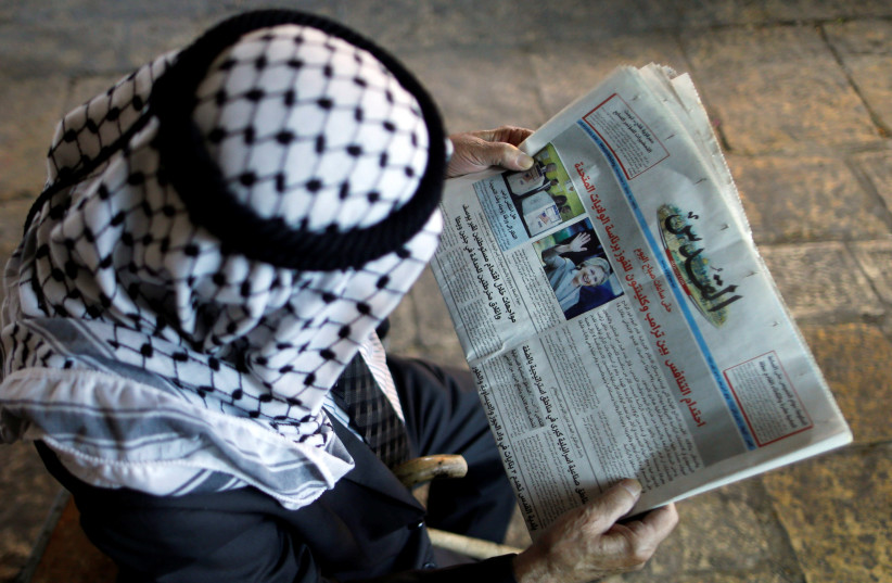 A Palestinian man reads the Al-Quds newspaper depicting images newly elected U.S. President Donald Trump and Democratic presidential nominee Hillary Clinton in Jerusalem's Old City November 9, 2016 (photo credit: AMMAR AWAD/REUTERS)