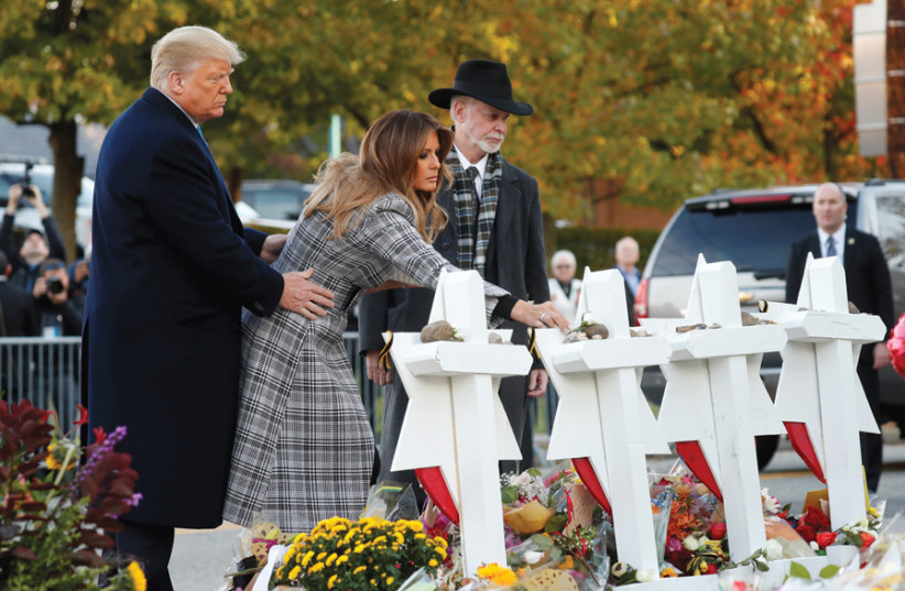 US PRESIDENT DONALD TRUMP and First Lady Melania Trump place stones on a memorial to shooting victims as they stand with Tree of Life Synagogue Rabbi Jeffrey Myers, outside the synagogue where white nationalist Robert Bowers killed 11 people and wounded six during a mass shooting in Pittsburgh, Penn (photo credit: KEVIN LAMARQUE/REUTERS)