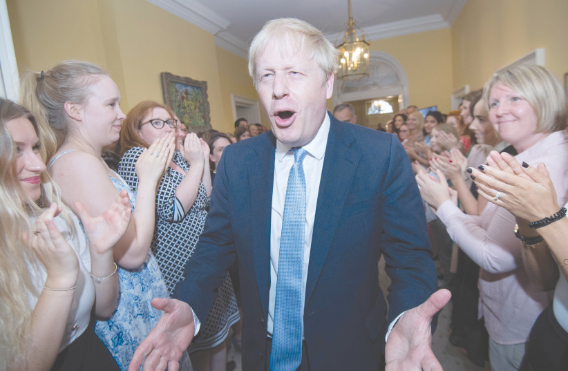 BRITAIN’S PRIME MINISTER Boris Johnson is welcomed in 10 Downing Street by staff on Wednesday.  (photo credit: STEFAN ROUSSEAU/REUTERS)