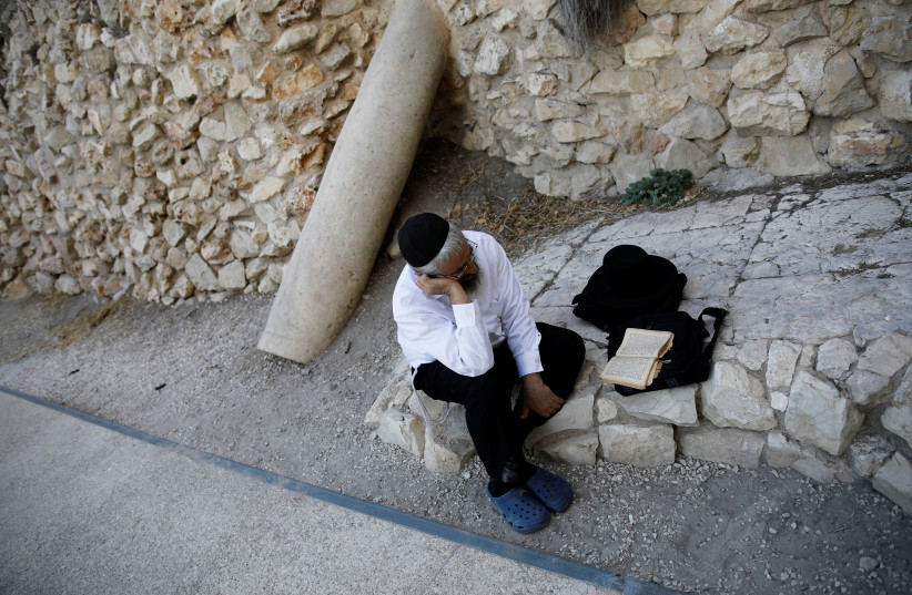ewish worshipper prays next to a pillar that Israeli archeaologists say formed part of the Second Temple, next to the Western Wall on Tisha Be'Av. (photo credit: AMIR COHEN/REUTERS)