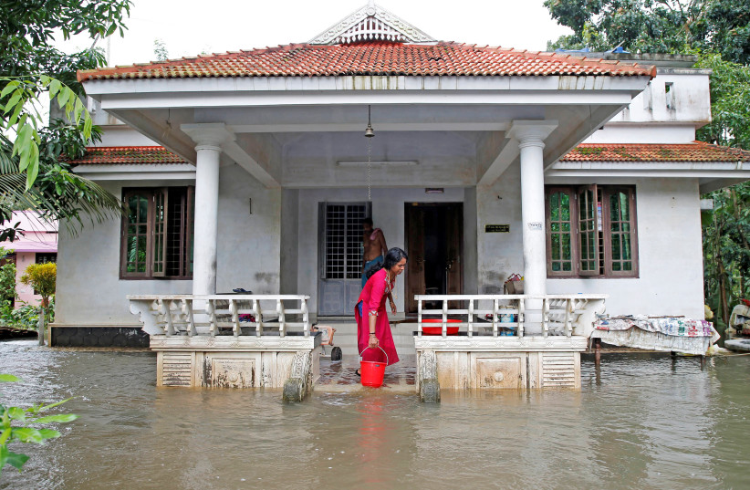 A woman clears out the water from her flooded house at Paravur on the outskirts of Kochi, in the southern state of Kerala, India August 11, 2019 (credit: REUTERS/SIVARAM V)