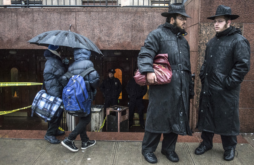 Two religious men stand outside outside the entrance to the world headquarters of the Chabad-Lubavitch movement at a Brooklyn synagogue in New York. (photo credit: STEPHANIE KEITH/REUTERS)
