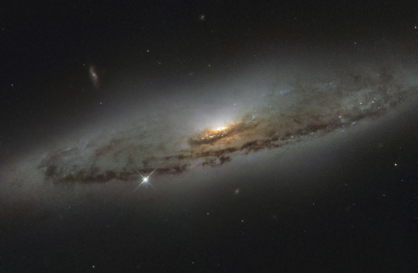 The spiral galaxy NGC 4845, located over 65 million light-years away in the constellation of Virgo in NASA/ESA Hubble Space Telescope image (photo credit: NASA/HANDOUT VIA REUTERS)