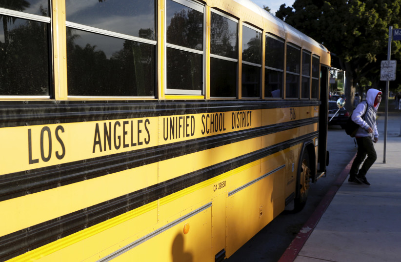 A student exits a bus as he arrives at Venice High School in Los Angeles, California (photo credit: JONATHAN ALCORN/REUTERS)