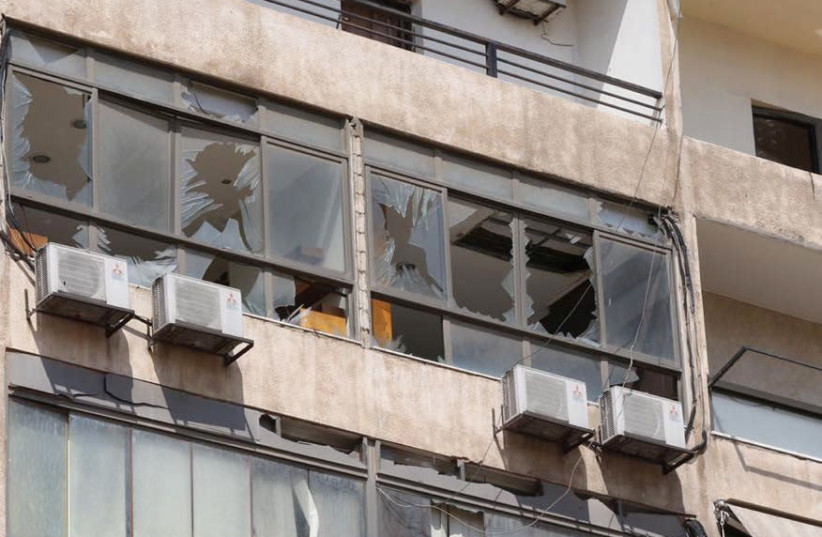Broken windows are pictured after an Israeli drone fell in the Hezbollah-dominated southern suburbs and a second one exploded near the ground in Dahiyeh suburbs of Beirut, Lebanon August 25, 2019 (photo credit: MOHAMED AZAKIR / REUTERS)