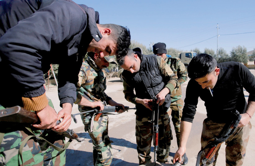 Yazidi fighters clean weapons at their headquarters in Sinjar, in February (credit: KHALID AL MOUSILY / REUTERS)