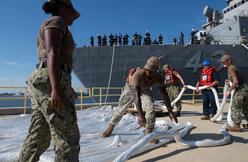 Sailors assigned to Naval Station Mayport lay down mooring lines as the amphibious dock landing ship USS Ft. McHenry is moved in preparation for Hurricane Dorian at Naval Station Mayport, in Jacksonville Florida, U.S. in this August 29, 2019 handout photo. (photo credit: MASS COMMUNICATION SPECIALIST 2ND CLASS DEVIN BOWSER/U.S. NAVY/HANDOUT VIA REUTERS)