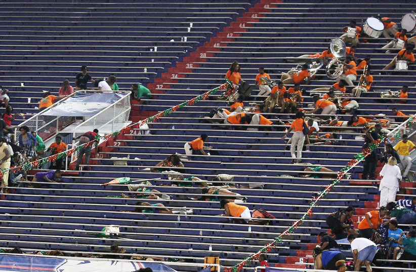 LeFlore fans and students take cover after gunfire rings out at the conclusion of the Williamson and LeFlore prep football game Friday, August 30, 2019, at Ladd-Peebles Stadium in Mobile, Ala (photo credit: MIKE KITTRELL/TNS)