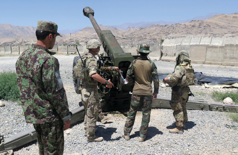 US MILITARY advisers from the 1st Security Force Assistance Brigade work with Afghan soldiers at an artillery position on an Afghan National Army base in Maidan Wardak province, Afghanistan in 2018 (photo credit: REUTERS)