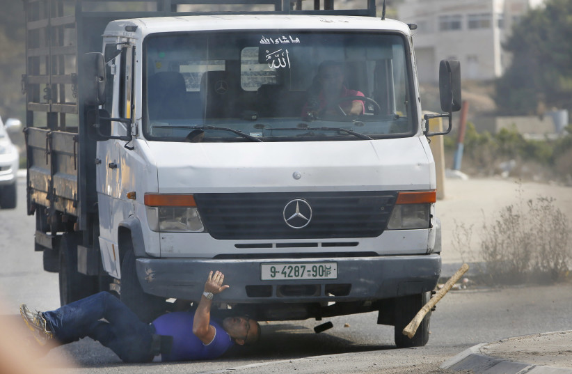 A Palestinian vehicle rams into Israeli Avraham Hasno, who died later, in Hebron (photo credit: MUSSA QAWASMA/REUTERS)