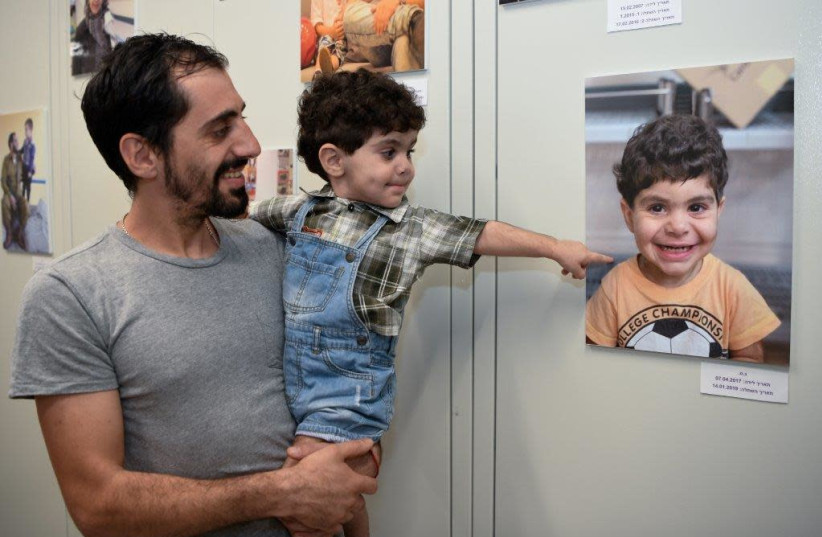 A father holds his son who had a bone marrow transplant at Hadassah during the ceremony to inaugurate the new center (photo credit: AVI HAYUN)