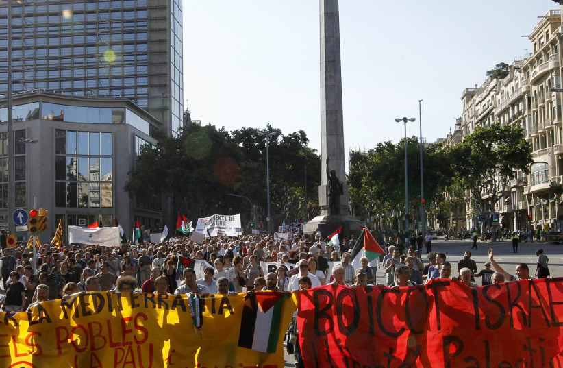 Pro-Palestinian protesters hold banners reading "Peace and solidarity of Mediterranean people" (L) and "Boycott Israel, Free Palestine" (R) as they demonstrate against Israel's raid on a Gaza-bound aid flotilla, in Barcelona June 5, 2010 (photo credit: GUSTAV NACARINO / REUTERS)