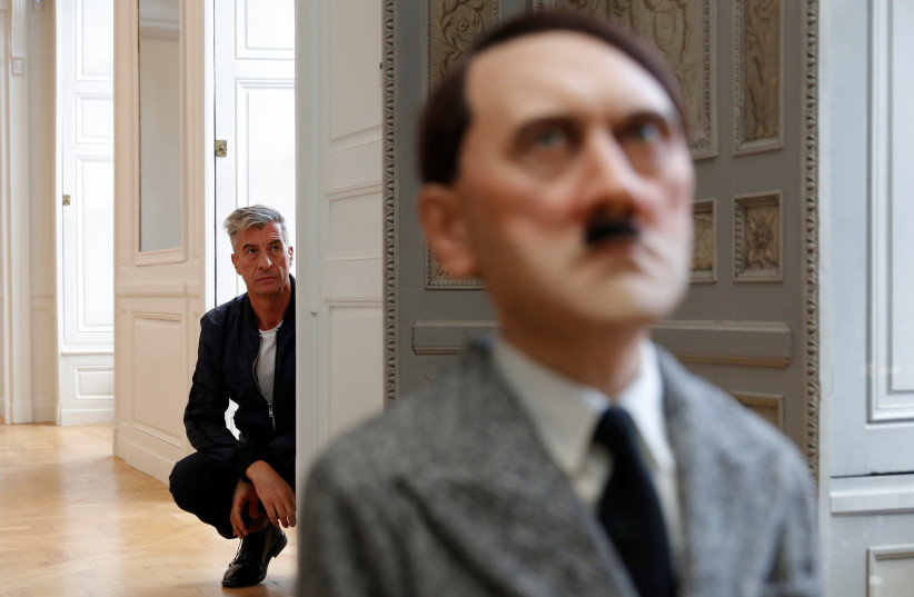 Italian artist Maurizio Cattelan poses with his creation "Him" (2001) prior to the opening of the exhibition "Not Afraid of Love" at the Hotel de la Monnaie in Paris, France, October 17, 2016.  (photo credit: PHILIPPE WOJAZER / REUTERS)