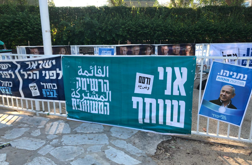 Posters for the Joint List, Labor, Likud, and Blue and White parties outside of the polling station at Gabrieli Carmel School in Tel Aviv (photo credit: JERUSALEM POST)