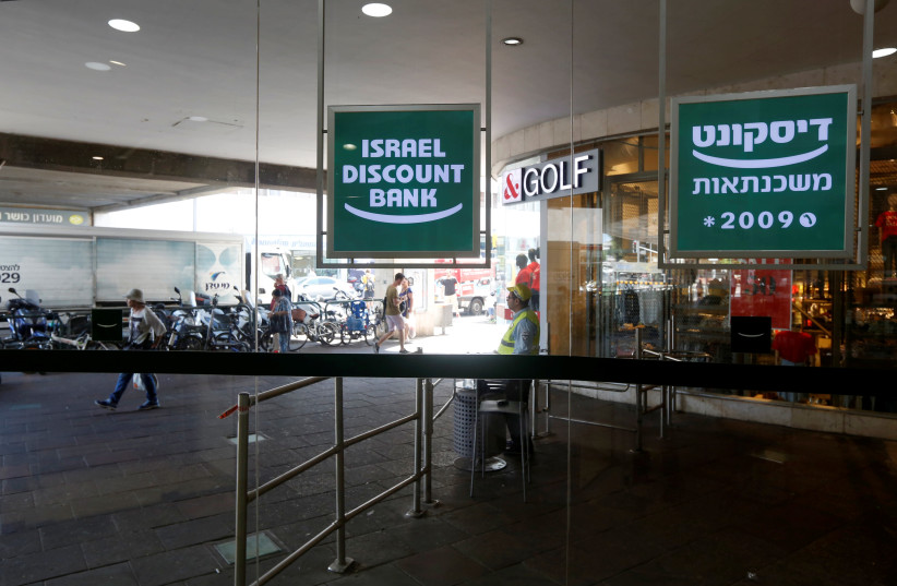 The logo of Israel Discount Bank is reflected in mirrors outside their branch in Tel Aviv, Israel July 27, 2016 (photo credit: BAZ RATNER/REUTERS)