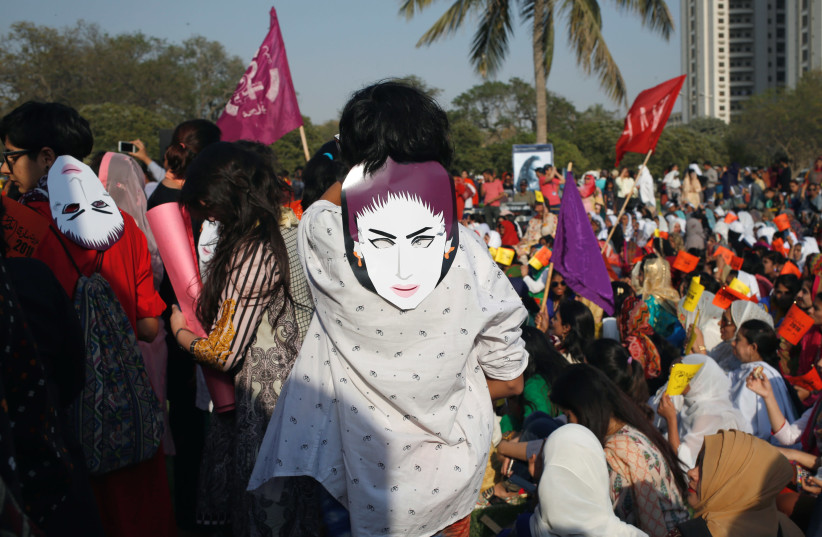 People wear masks depicting Qandeel Baloch, as they take part in an Aurat March, or Women's March in Karachi (photo credit: REUTERS)