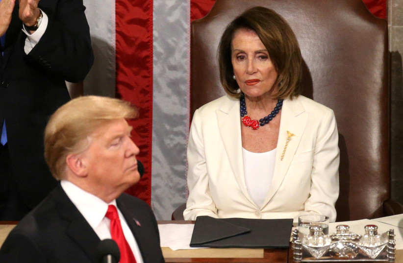 Speaker of the House Nancy Pelosi (D-CA) reacts alongside Vice President Mike Pence as he applauds U.S. President Donald Trump during his second State of the Union address to a joint session of the U.S. Congress in the House Chamber of the U.S. Capitol on Capitol Hill in Washington, U.S. February 5, (photo credit: LEAH MILLIS/REUTERS)