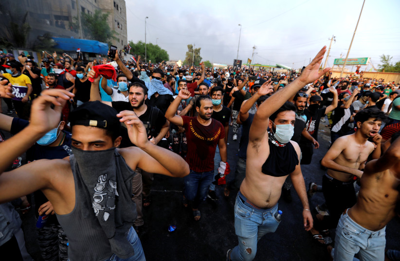 Demonstrators gesture at a protest over unemployment, corruption and poor public services, in Baghdad, Iraq October 2, 2019 (photo credit: REUTERS/THAIER AL-SUDANI)