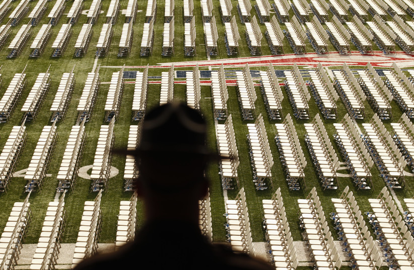 A police officer looks out at rows of empty chairs before the Liberty University commencement ceremony in Lynchburg, Virginia May 12, 2012. Mitt Romney, U.S. Republican presidential candidate and former Massachusetts governor, gave the keynote address at the ceremony (photo credit: REUTERS/KEVIN LAMARQUE)