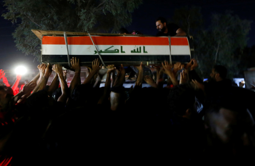 Men carry the coffin of a demonstrator who was killed during anti-government protests, in Baghdad, Iraq October 4, 2019. Picture taken October 4, 2019 (photo credit: WISSIM AL-OKILI/REUTERS)