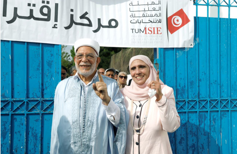 ABDELFATTAH MOUROU of the Ennahda Party and his wife show off their ink-stained fingers after casting their vote at a polling station during the presidential election, in Tunis on September 15. (Zoubeir Souissi/Reuters) (photo credit: ZOUBEIR SOUISSI / REUTERS)