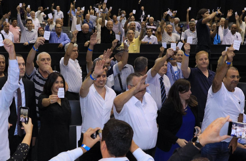 Likud politicians Miki Zokar, Miri Regev, David Bitan and Tzipi Hotovely vote in favor of a proposal reiterating Prime Minister Benjamin Netanyahu's leadership Thursday at a sparsely attended Likud central committee meeting at the Tel Aviv Fairgrounds. (photo credit: LIKUD)