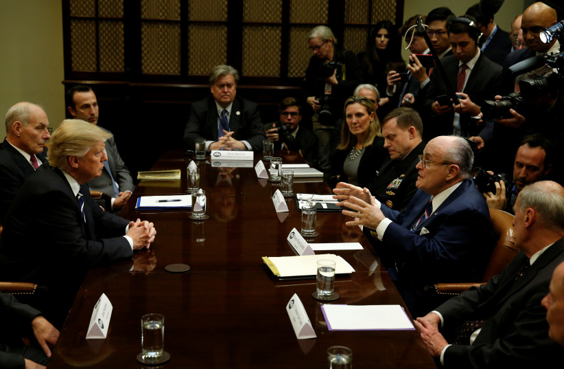 U.S. President Donald Trump listens to former New York City Mayor Rudy Giuliani during a meeting with cyber security experts in the Roosevelt Room of the White House in Washington, U.S., January 31, 2017.  (photo credit: REUTERS/KEVIN LAMARQUE)