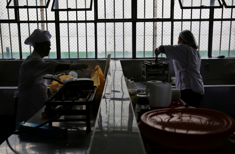 Inmates prepare food during a culinary competition called 'Inpe Mistura 2016', where prisoners from different jails took on the roles of cooks and assistants, at the Chorrillos women's jail in Lima, Peru. September 7, 2016 (photo credit: MARIANA BAZO/REUTERS)