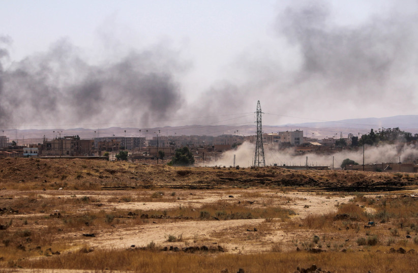 Smoke rises after what Kurdish People's Protection Units (YPG) fighters said was shelling by them on locations controlled by Islamic State fighters in Ghwayran neighborhood in Hasaka city, Syria July 22, 2015. A Syrian Kurdish militia said on Monday it was in near full control of the northeastern ci (credit: REUTERS/RODI SAID)