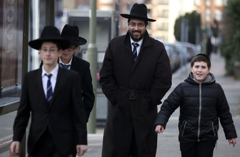 A Jewish man walks with young Jewish boys in Golders Green, London, January 10 , 2015. The Community Security Trust (CST), which provides security advice to Britain's estimated 260,000 Jews, said police in London and Manchester in northern England had agreed to increase patrols at synagogues and oth (photo credit: PAUL HACKETT/REUTERS)