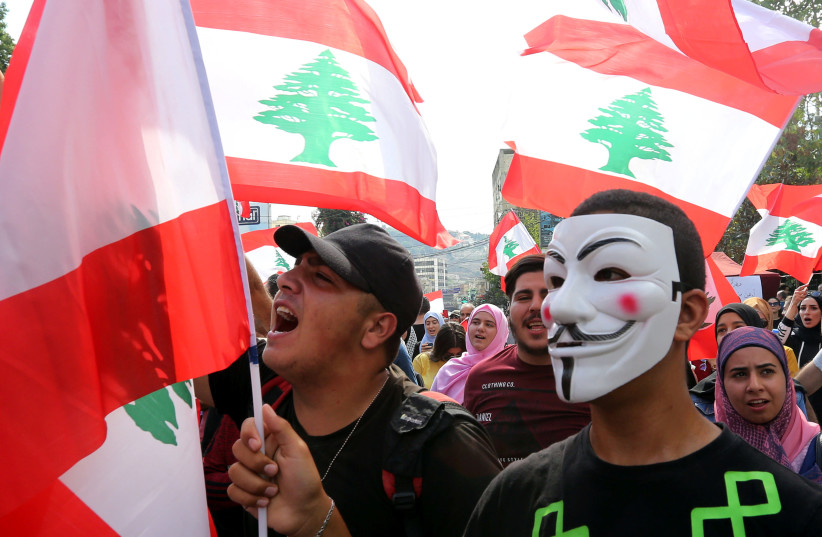 A demonstrator wears a Guy Fawkes mask during an anti-government protest in the southern city of Nabatiyeh, Lebanon October 20, 2019.  (photo credit: AZIZ TAHER/REUTERS)