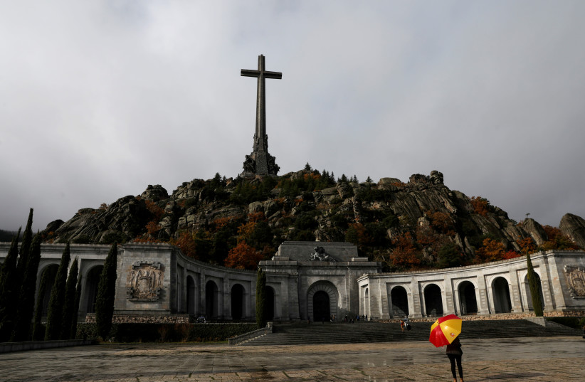 A woman holds an umbrella at the Valley of the Fallen, the mausoleum holding the remains of former Spanish dictator Francisco Franco in San Lorenzo de El Escorial, otuside Madrid (photo credit: REUTERS)