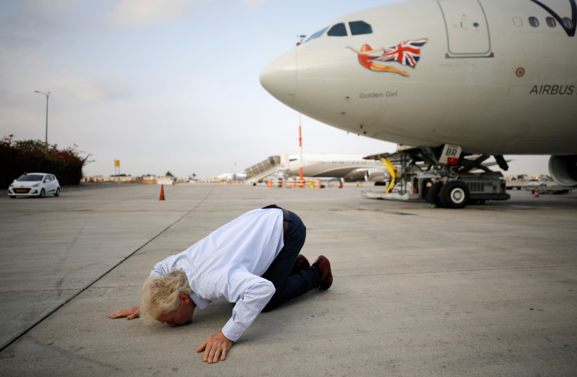 Virgin's Richard Branson kisses the ground as he lands at the Ben Gurion international airport near Tel Aviv, Israel, October 23, 2019 (photo credit: REUTERS/AMIR COHEN)