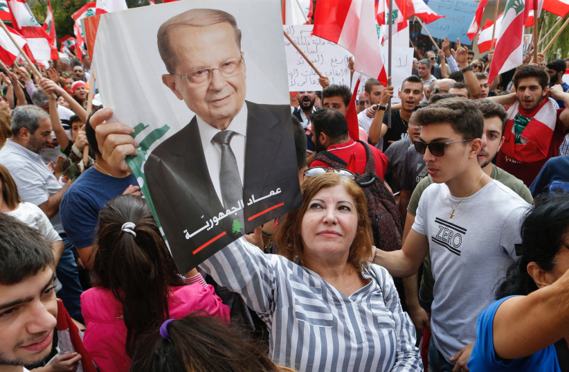Supporters of Lebanese President Michel Aoun carry his picture near the presidential palace in Baabda, ahead of his address to the nation (photo credit: REUTERS/MOHAMED AZAKIR)