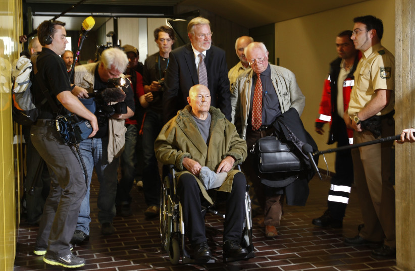 Convicted Nazi death camp guard John Demjanjuk leaves a courtroom after his the verdict in Munich on May 12, 2011. Convicted Nazi camp guard John Demjanjuk, 91, will be released from jail despite his five-year sentence for helping to kill 27,900 Jews at the Nazi death camp Sobibor because of his adv (photo credit: REUTERS/MICHAEL DALDER)